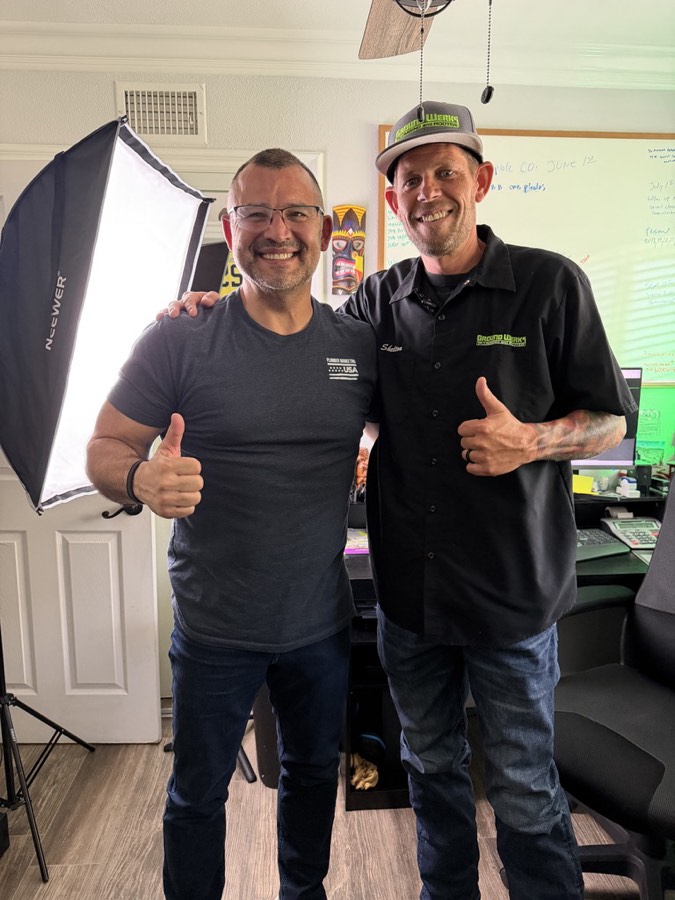 Richard Cruz and the owner of Ground Werks Plumbing and Rooter giving a thumbs up in front of a video light on filming day